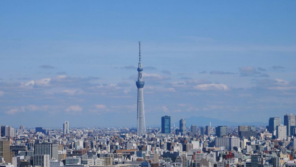 Stunning aerial view of Tokyo cityscape featuring the iconic Skytree Tower under a blue sky.